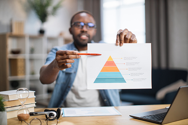 Young male freelancer in casual wear and eyeglasses showing financial report on camera during online meeting from home. First person view.